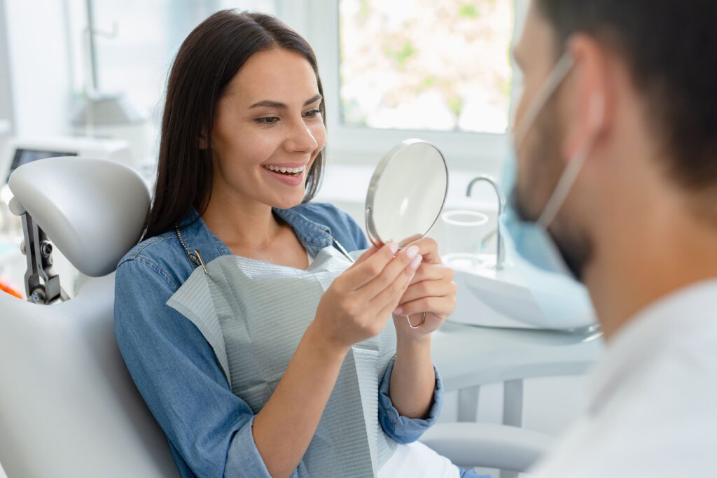 enfoque selectivo mujer joven que mira espejo despues procedimiento dental 1